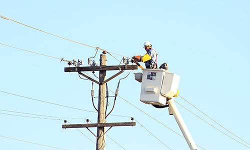 A lineman in a bucket truck repairs a power line