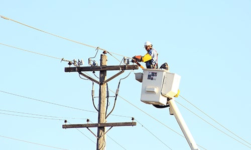 A lineman works on a power line in a bucket truck.