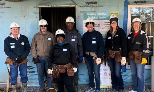 CREC employees stand in front of a Habitat for Humanity home