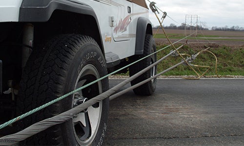 A jeep runs up right next to a downed power line.