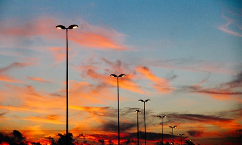 A row of streetlights at dusk.