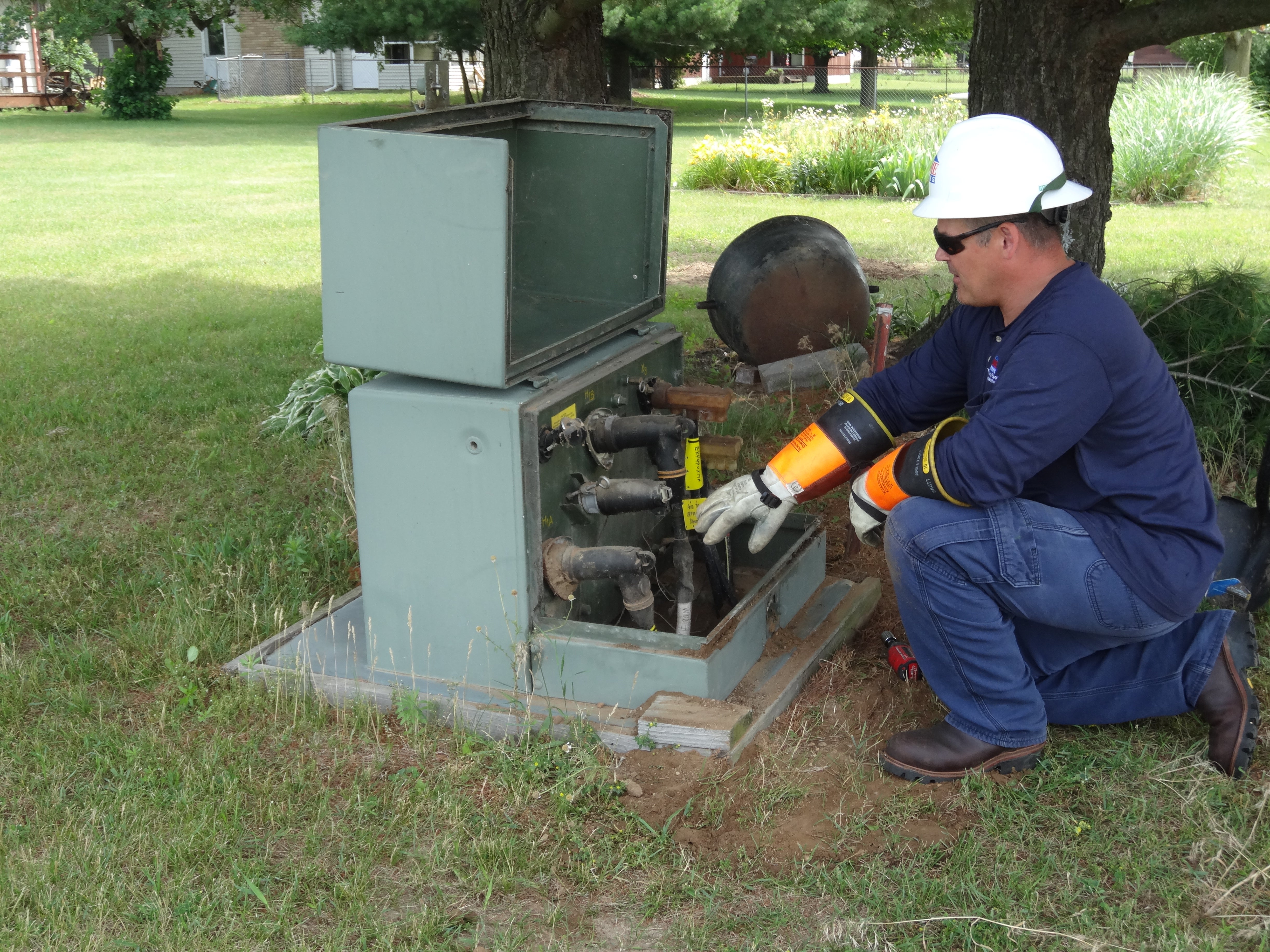 A lineman checks a pad mount transformer