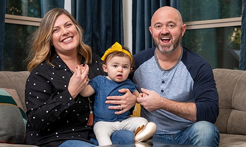 A family sits on a couch.